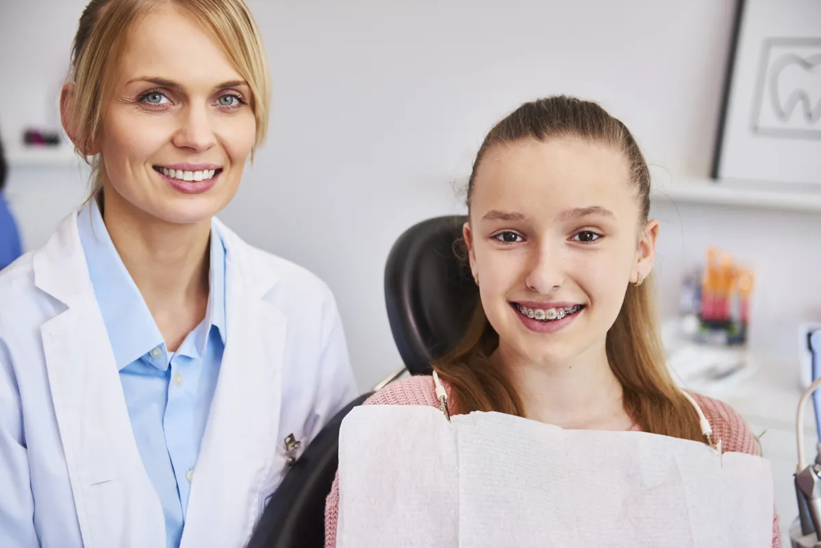 Girl with braces and her orthodontist in the clinic